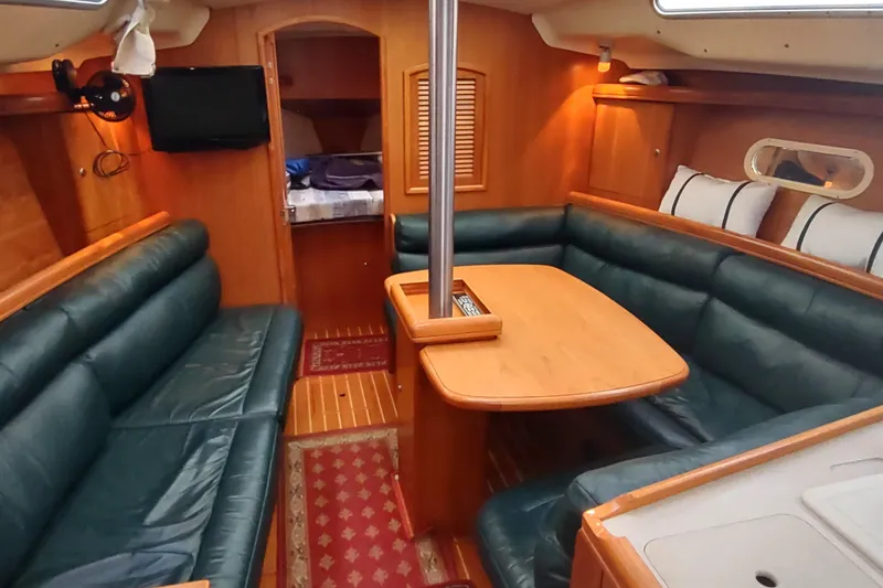 Slide: The Image of Luxurious interior of 2003 Hunter 356 sailboat with green leather seating and wooden finishes. - 27