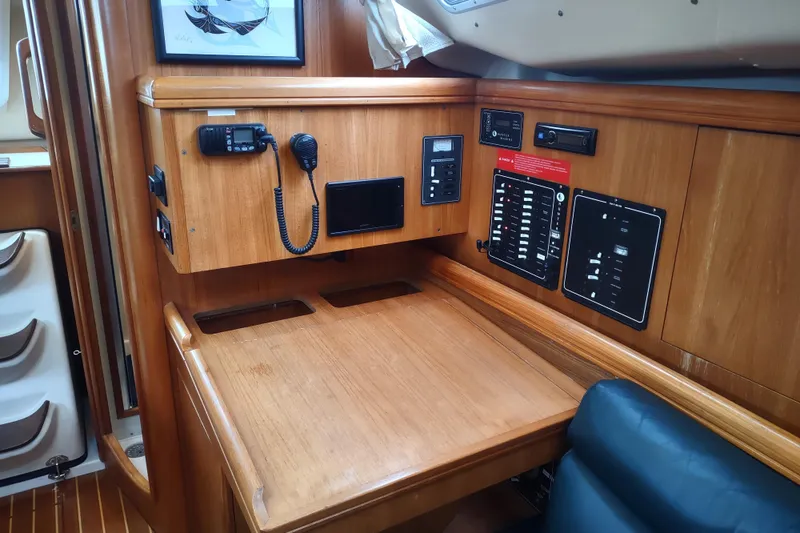 Slide: The Image of 2003 Hunter 356 yacht navigation station with communication equipment and control panels. - 35