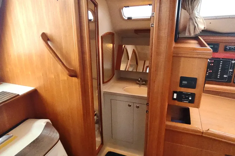 Slide: The Image of 2003 Hunter 356 yacht interior with wooden cabinetry and compact bathroom. - 38