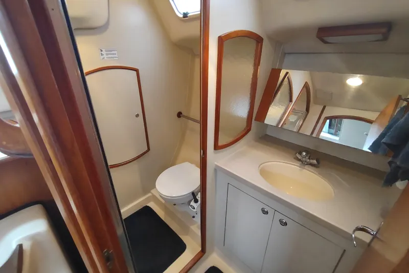 Slide: The Image of 2003 Hunter 356 yacht bathroom with sink, toilet, and mirror. - 41