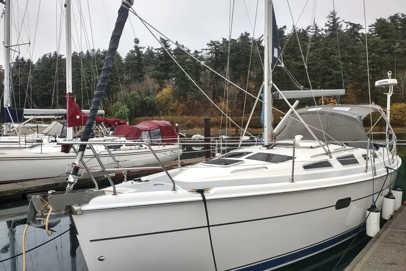 Slide: The Image of 2003 Hunter 356 sailboat docked in a marina, surrounded by trees. - 6