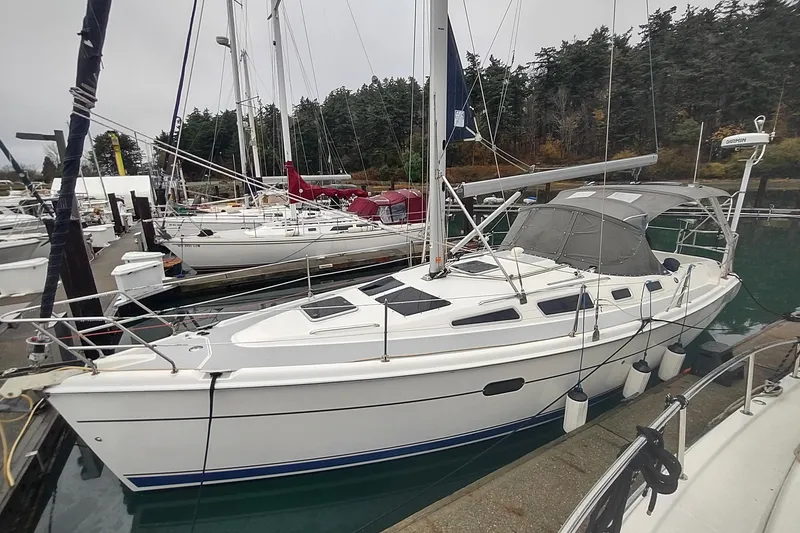 Slide: The Image of 2003 Hunter 356 sailboat docked at marina, surrounded by other boats. - 7