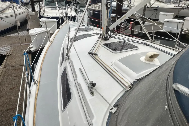 Slide: The Image of 2003 Hunter 356 sailboat docked at marina, showcasing deck and rigging details. - 8
