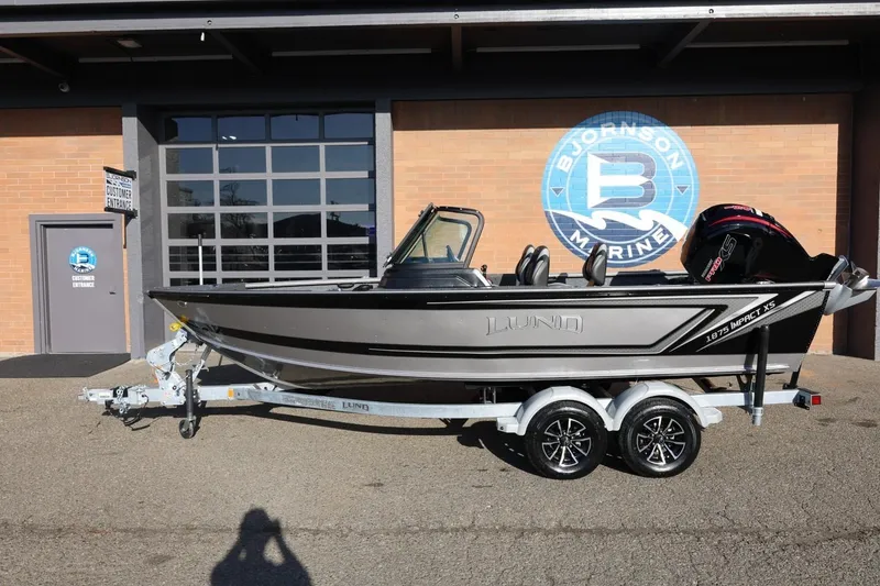 Slide: The Image of 2026 Lund 1875 Impact XS Sport boat on trailer outside Bjornson Marine. - 1