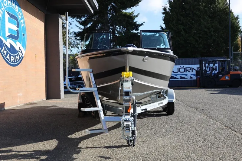 Slide: The Image of 2026 Lund 1875 Impact XS Sport boat on trailer at marine dealership. - 10