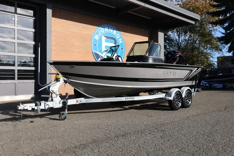 Slide: The Image of 2026 Lund 1875 Impact XS Sport boat on trailer outside dealership. - 12