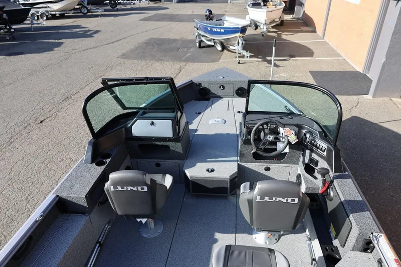 Slide: The Image of 2026 Lund 1875 Impact XS Sport boat interior with dual consoles and seating. - 13