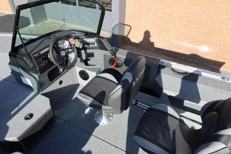 Slide: The Image of 2026 Lund 1875 Impact XS Sport boat interior with steering wheel and seating. - 14