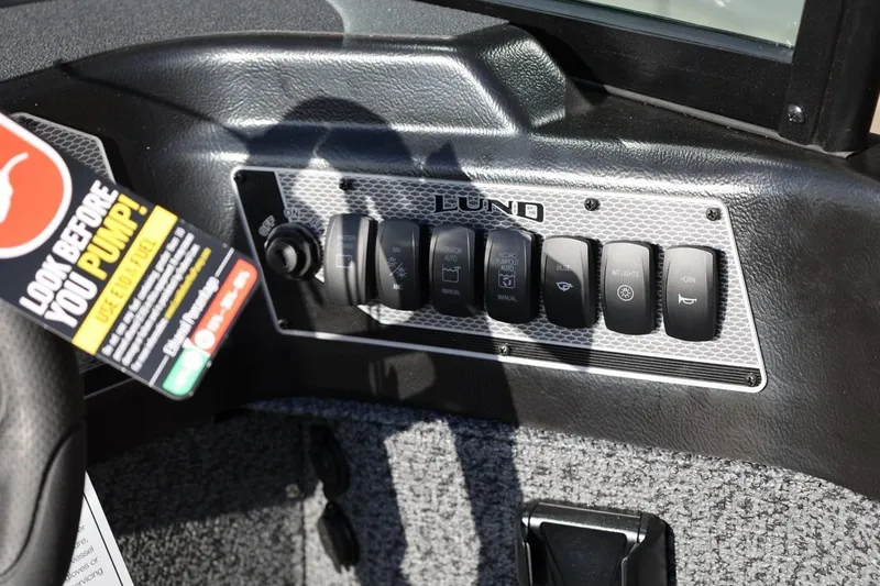 Slide: The Image of Control panel of 2026 Lund 1875 Impact XS Sport boat with various switches. - 17