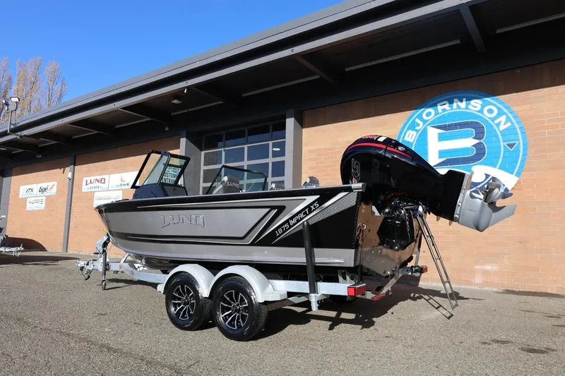 Slide: The Image of 2026 Lund 1875 Impact XS Sport boat on trailer outside Bjornson building. - 2