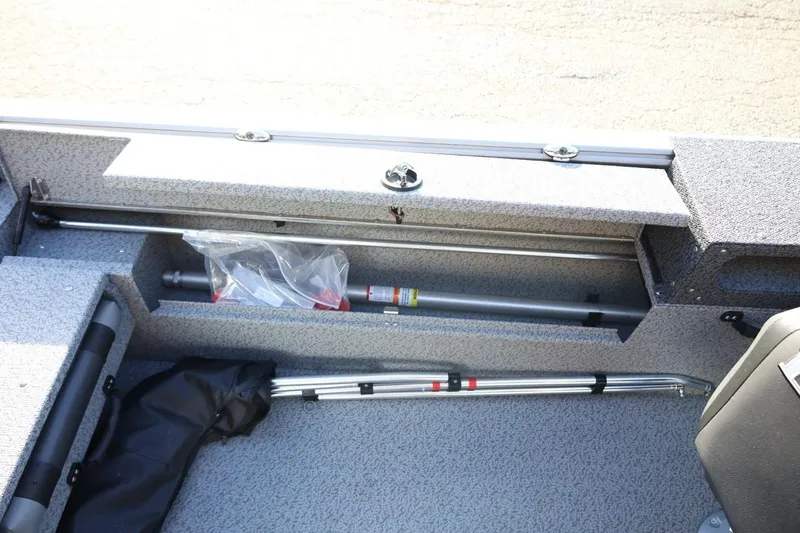 Slide: The Image of Storage compartment of 2026 Lund 1875 Impact XS Sport boat, featuring organized equipment. - 27