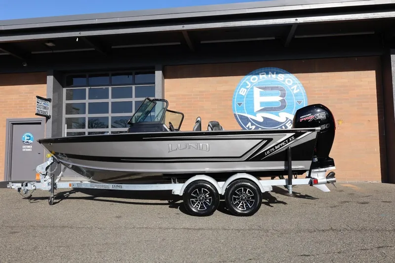 Slide: The Image of 2026 Lund 1875 Impact XS Sport boat on trailer outside dealership. - 42