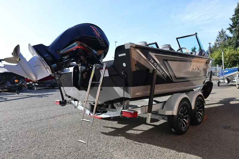 Slide: The Image of 2026 Lund 1875 Impact XS Sport boat on trailer, featuring powerful outboard motor. - 6