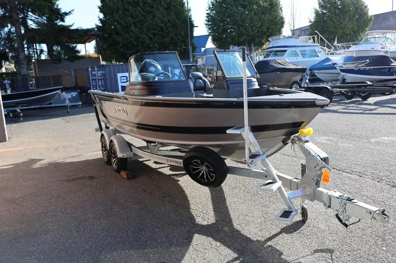 Slide: The Image of 2026 Lund 1875 Impact XS Sport boat on trailer in marina setting. - 7