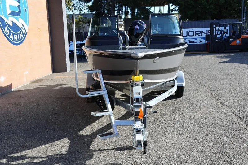 Slide: The Image of 2026 Lund 1875 Impact XS Sport boat on trailer, parked outside marine shop. - 9