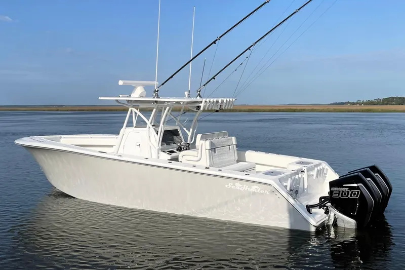 Slide: The Image of 2022 SeaHunter 33 Tournament boat with triple Mercury 300 engines on calm water. - 2