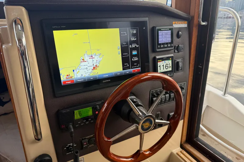 Slide: The Image of 2017 Ranger Tugs R-31 CB helm with navigation display and wooden steering wheel. - 10
