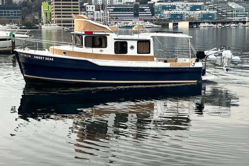 Slide: The Image of 2017 Ranger Tugs R-31 CB boat named "Sweet Seas" docked in a marina. - 2