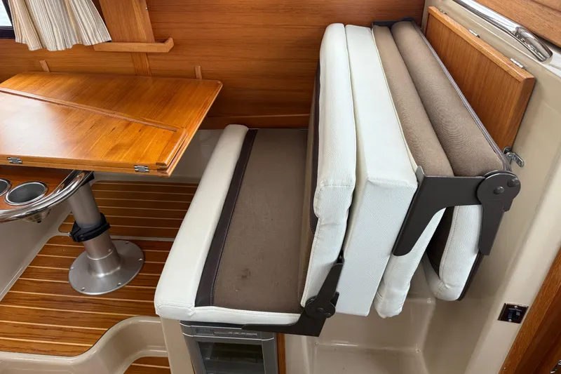 Slide: The Image of 2017 Ranger Tugs R-31 CB interior with foldable seating and wooden table. - 24