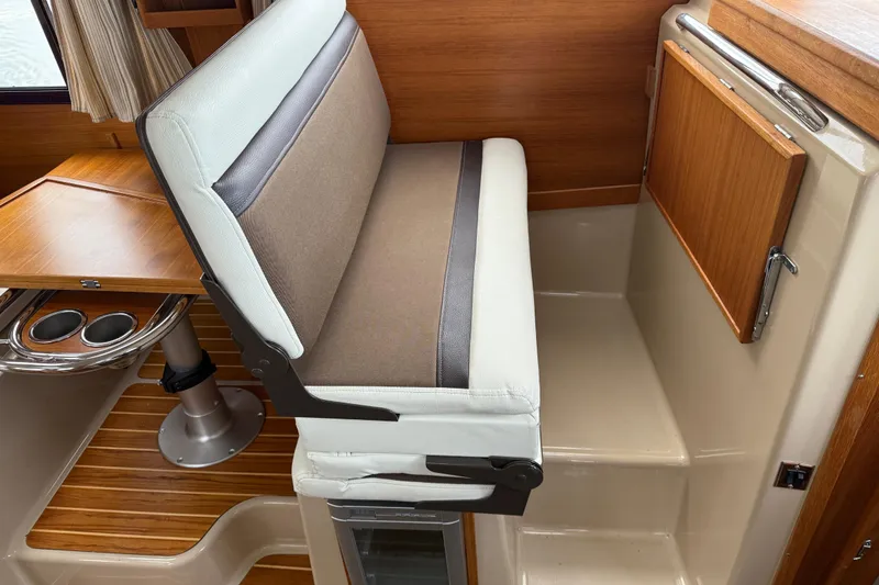 Slide: The Image of 2017 Ranger Tugs R-31 CB interior with cushioned seating and wooden accents. - 25
