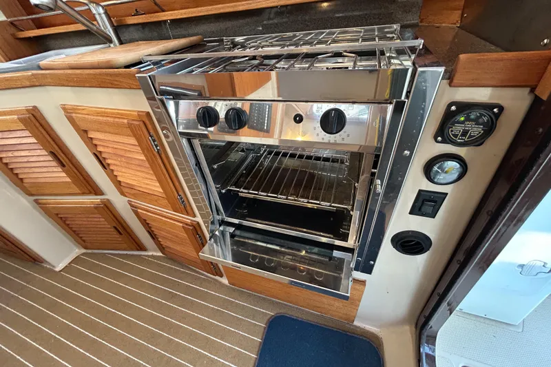 Slide: The Image of 2017 Ranger Tugs R-31 CB interior with stainless steel oven and wooden cabinetry. - 34