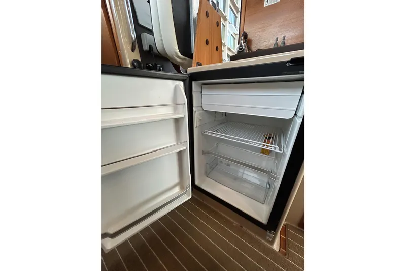 Slide: The Image of Open refrigerator inside 2017 Ranger Tugs R-31 CB boat, showing shelves and storage space. - 36