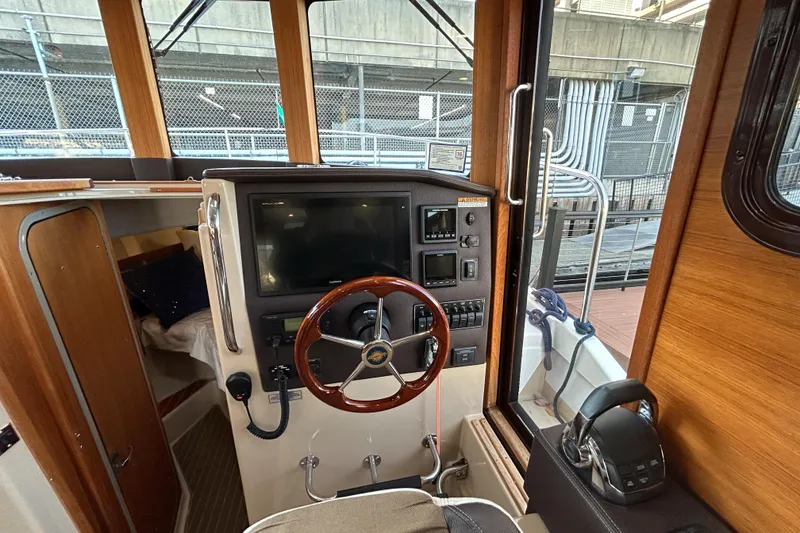 Slide: The Image of 2017 Ranger Tugs R-31 CB helm with wooden steering wheel and navigation controls. - 7