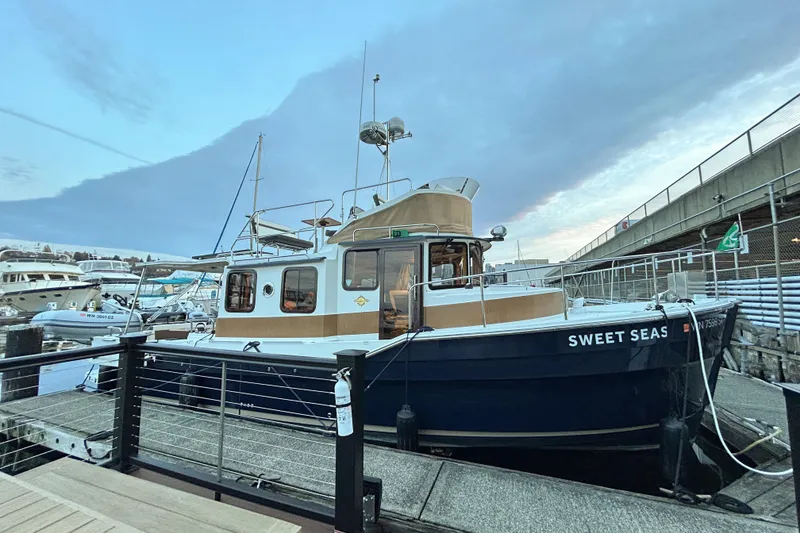 Slide: The Image of 2017 Ranger Tugs R-31 CB boat docked, named "Sweet Seas," under a cloudy sky. - 94