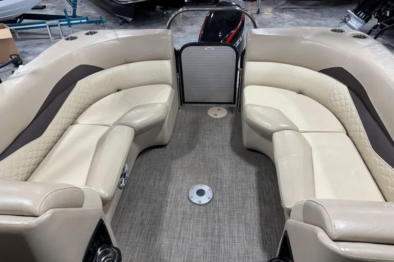 Slide: The Image of 2019 Manitou 250 Encore SHP boat interior with beige seating and carpeted floor. - 11