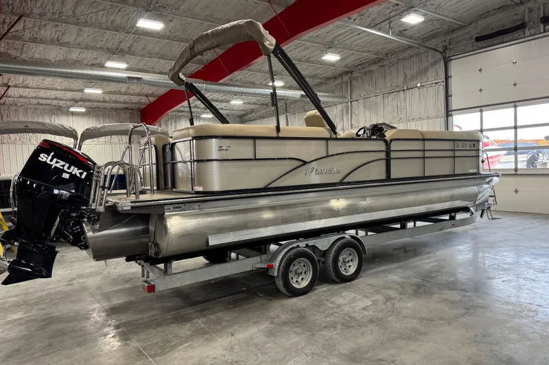 Slide: The Image of 2019 Manitou 250 Encore SHP pontoon boat with Suzuki outboard motor in a garage. - 3