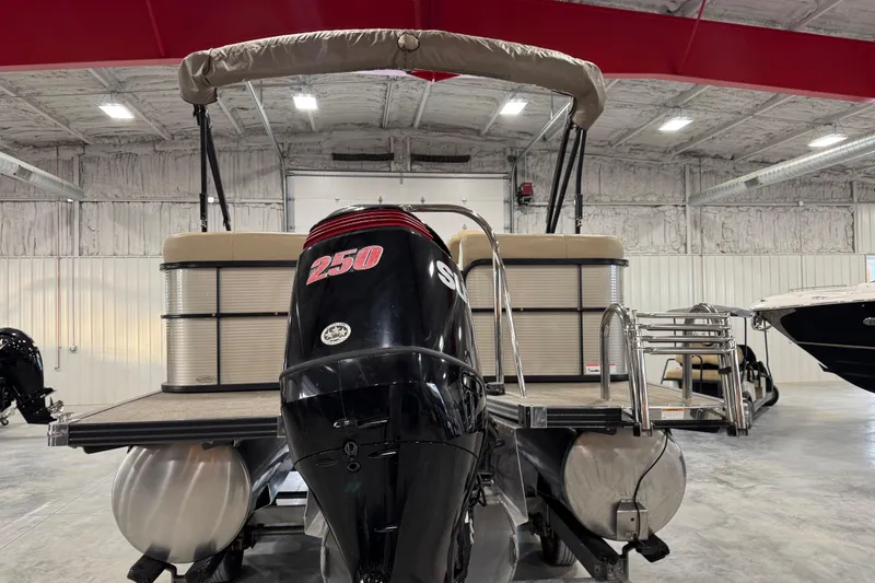 Slide: The Image of 2019 Manitou 250 Encore SHP pontoon boat in indoor storage facility. - 6