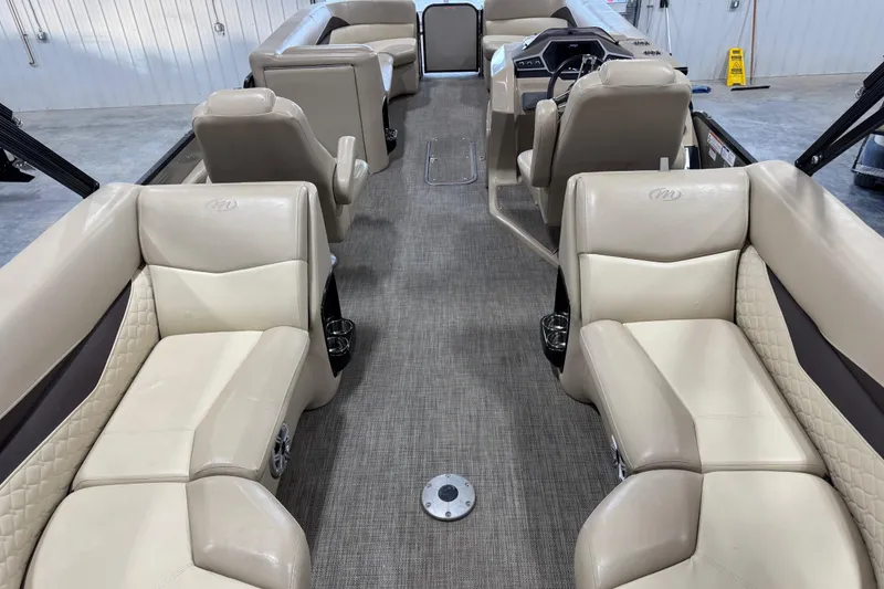 Slide: The Image of 2019 Manitou 250 Encore SHP pontoon boat interior with beige seating and modern dashboard. - 7