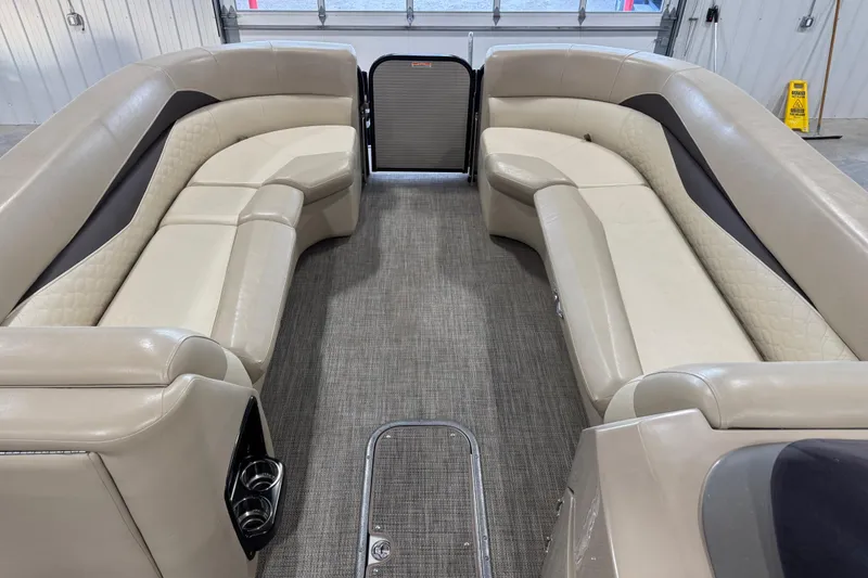 Slide: The Image of 2019 Manitou 250 Encore SHP pontoon boat interior with beige seating and carpeted floor. - 9