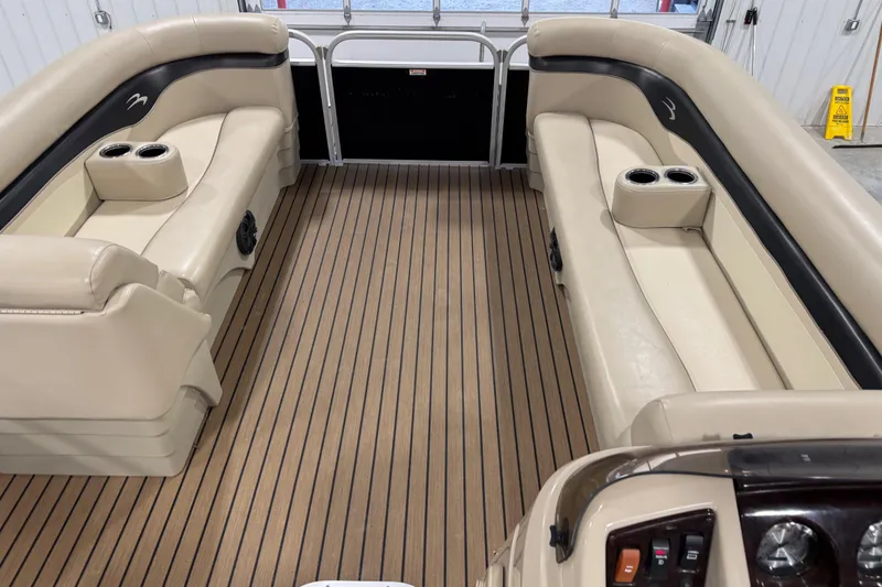 Slide: The Image of 2014 Bennington S 24 pontoon boat interior with beige seating and wood-style flooring. - 11