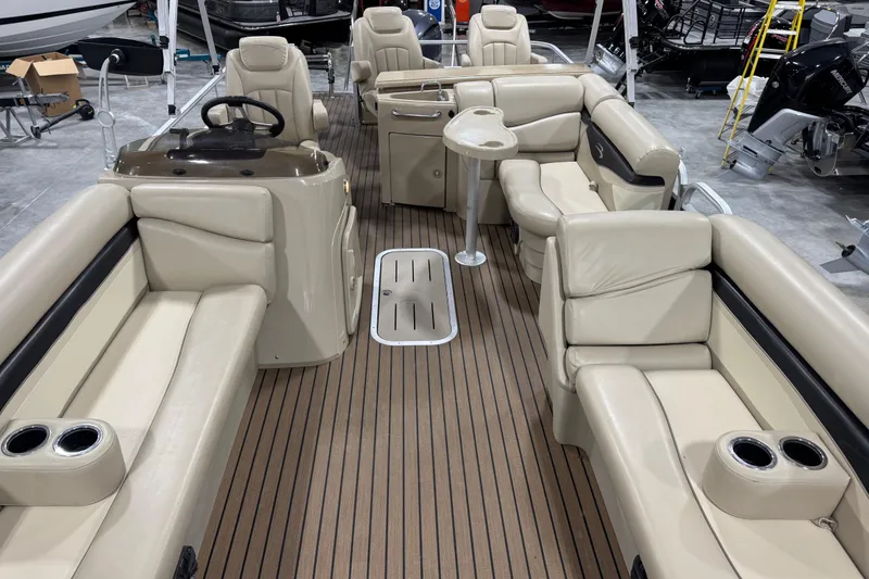 Slide: The Image of 2014 Bennington S 24 pontoon boat interior with beige seating and wood-style flooring. - 12