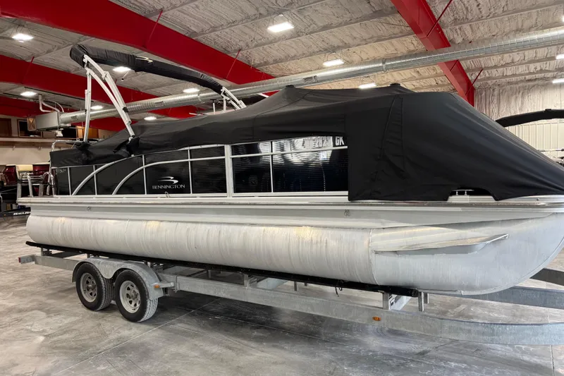 Slide: The Image of 2014 Bennington S 24 pontoon boat with black cover on trailer in indoor storage. - 6