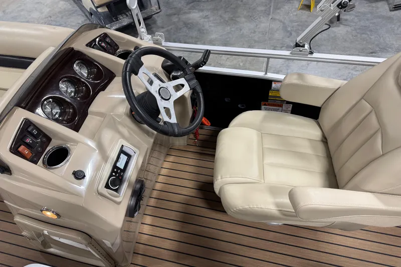 Slide: The Image of 2014 Bennington S 24 boat interior with steering wheel and beige captain's chair. - 7