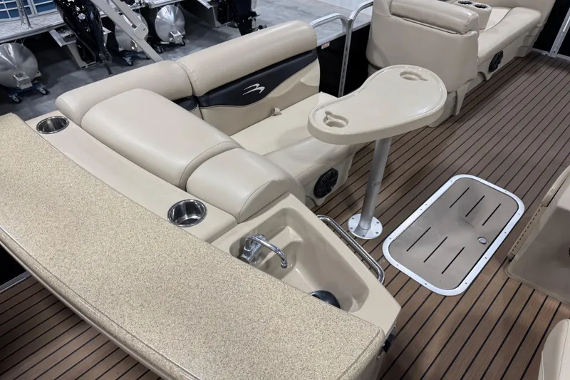 Slide: The Image of 2014 Bennington S 24 boat interior with beige seating and wood-style flooring. - 8