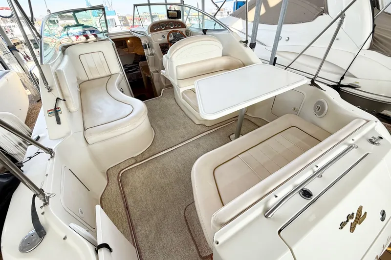 Slide: The Image of 2000 Sea Ray 270 Sundancer interior with seating and table, docked at marina. - 10