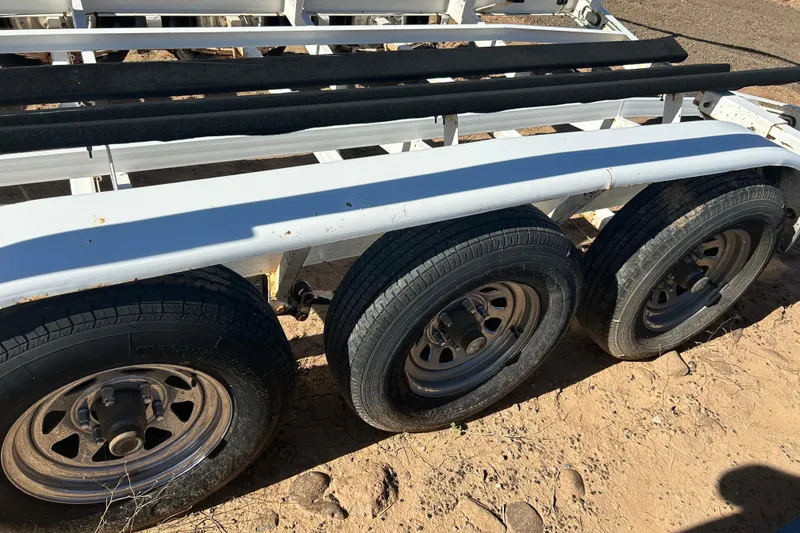 Slide: The Image of Triple-axle trailer for 2000 Sea Ray 270 Sundancer on sandy ground. - 28