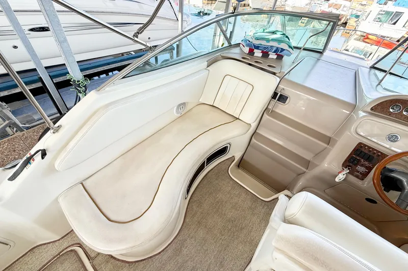 Slide: The Image of Interior of a 2000 Sea Ray 270 Sundancer boat with white seating and control panel. - 7