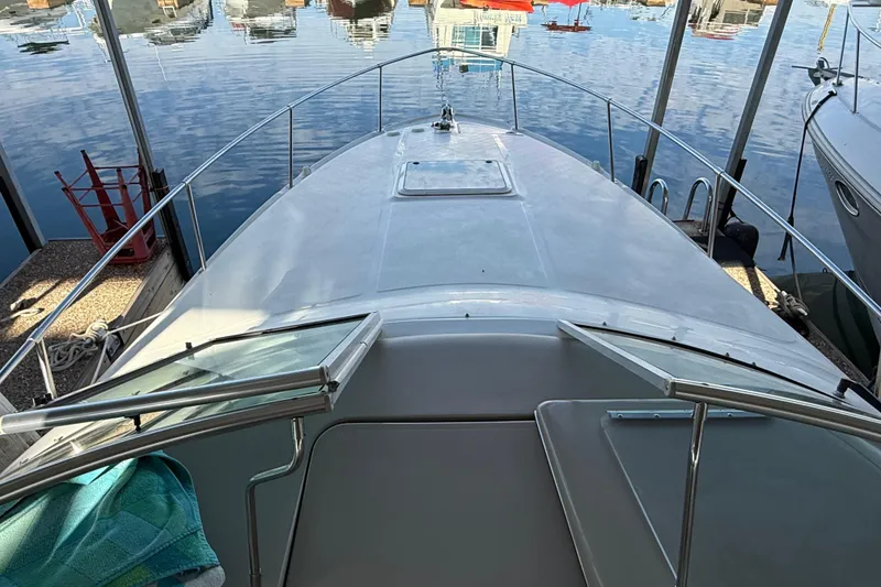 Slide: The Image of 2000 Sea Ray 270 Sundancer boat docked, view from the bow with open hatch. - 8