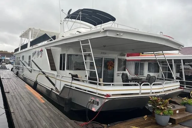 The Image of A 2008 Fantasy houseboat docked, featuring a spacious deck and modern design. - 0