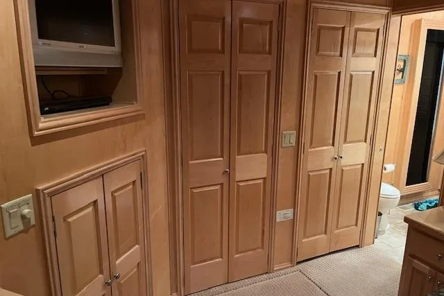 Slide: The Image of Interior of 2008 Fantasy houseboat with wooden cabinets and a small TV. - 12