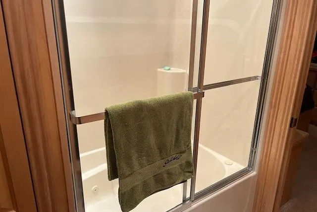 Slide: The Image of Shower area in 2008 Fantasy Houseboat with green towel on glass door. - 23