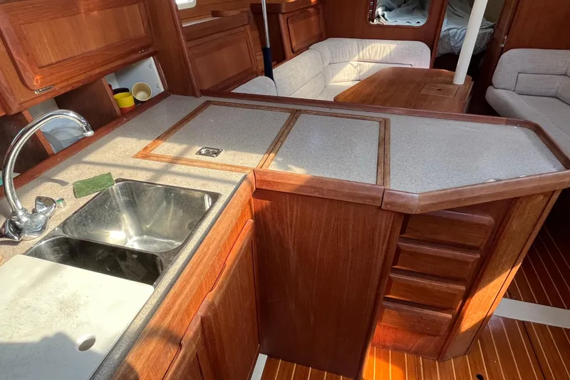 Slide: The Image of Interior of 1995 Hunter Legend 37.5 sailboat with wooden cabinetry and kitchen area. - 12