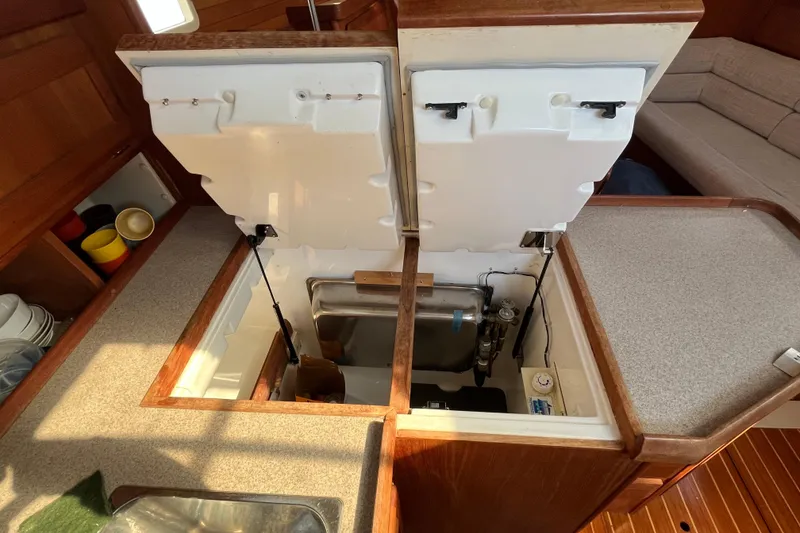 Slide: The Image of Interior of 1995 Hunter Legend 37.5 yacht showing open storage compartments and kitchen area. - 14