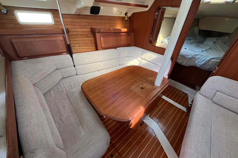 Slide: The Image of Interior of 1995 Hunter Legend 37.5 sailboat with cozy seating and wooden table. - 17