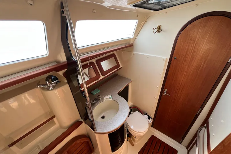 Slide: The Image of 1995 Hunter Legend 37.5 yacht bathroom with sink, toilet, and wooden accents. - 21
