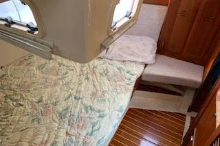 Slide: The Image of 1995 Hunter Legend 37.5 yacht cabin with bed, wooden flooring, and storage. - 23